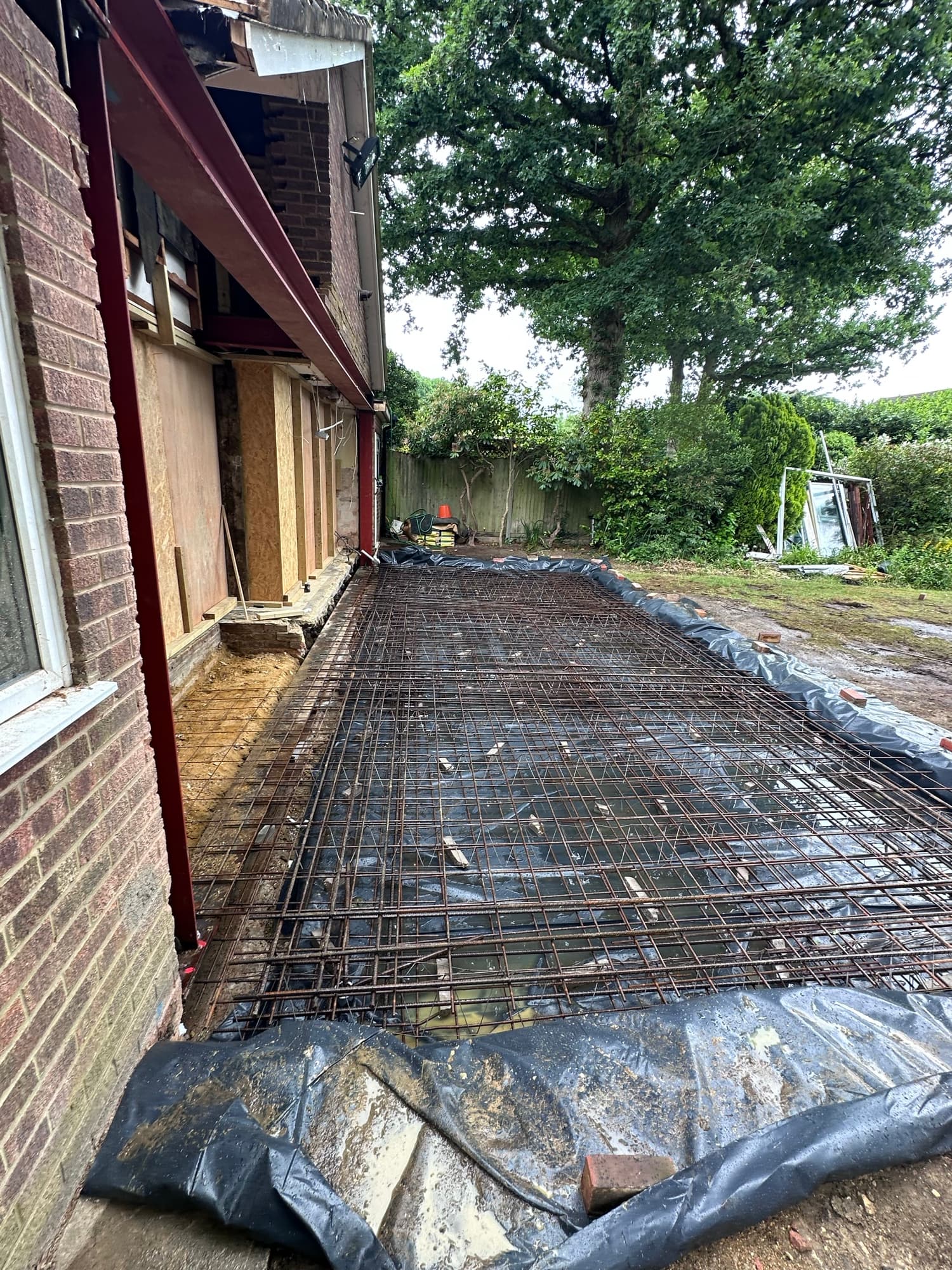 Demolition rubble stockpile and excavator during site preparation in Woking