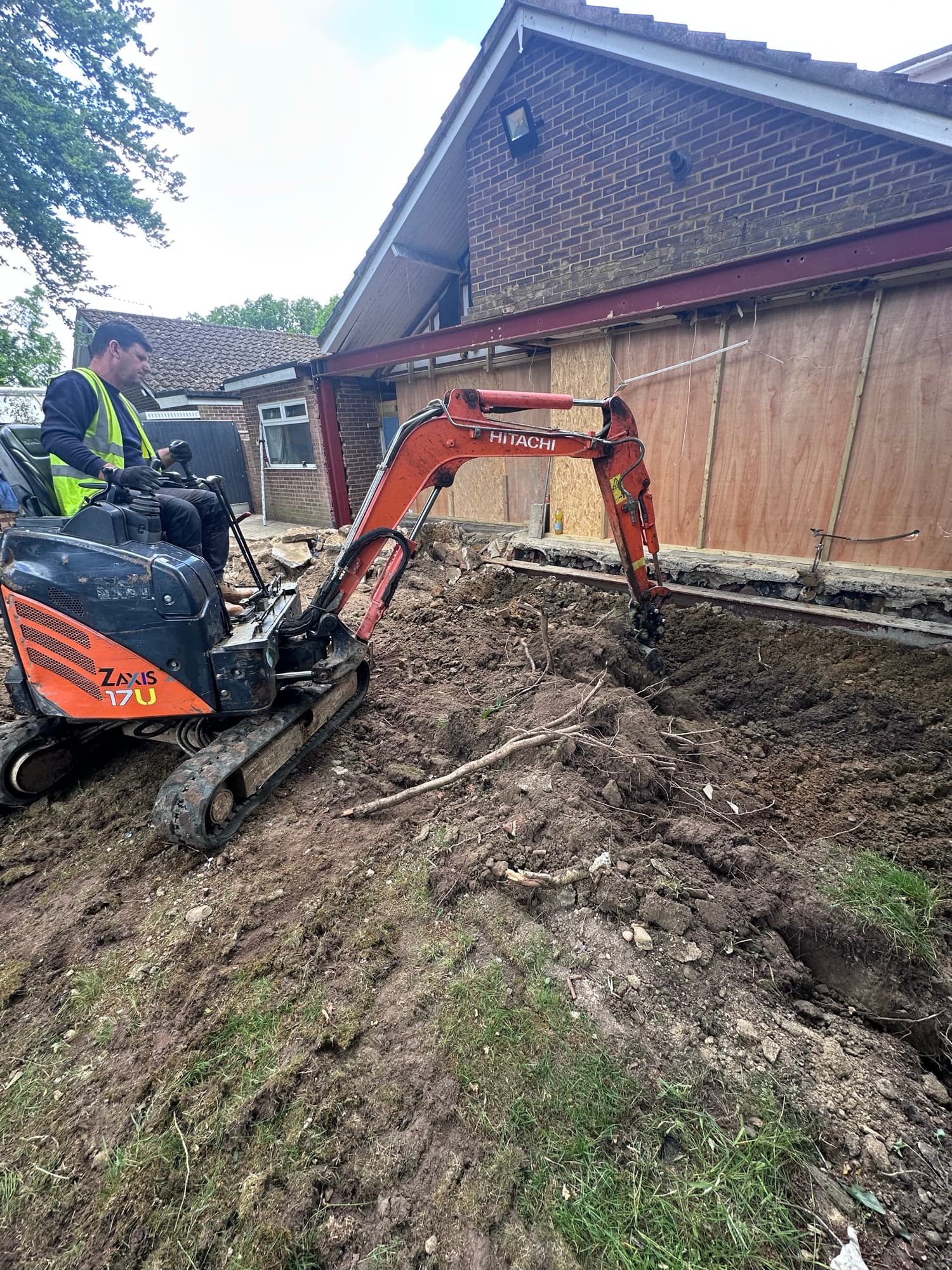 Mini excavator breaking out existing hardstanding at the Woking site